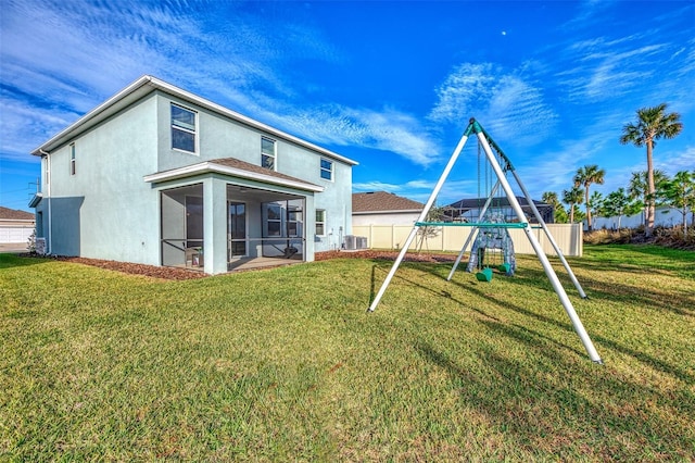 back of house featuring a playground, a sunroom, a yard, and central AC unit