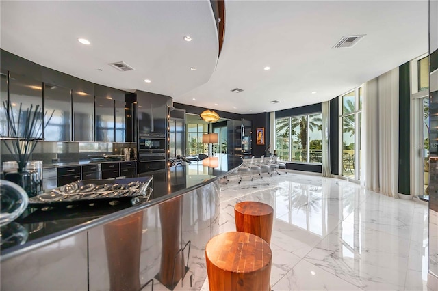 kitchen featuring marble finish floor, visible vents, and black oven