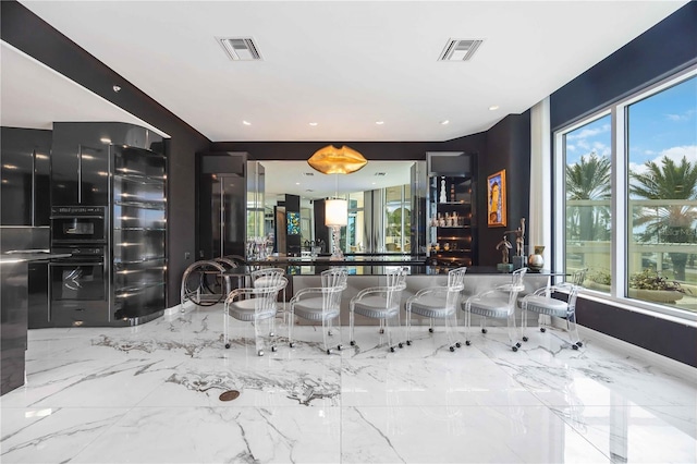 bathroom featuring marble finish floor, visible vents, and a healthy amount of sunlight