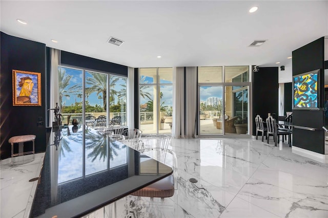 interior space with marble finish floor, expansive windows, visible vents, and recessed lighting