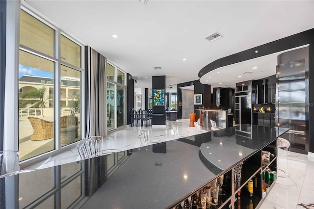 kitchen with expansive windows, marble finish floor, visible vents, and recessed lighting