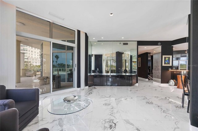 living area featuring marble finish floor, expansive windows, visible vents, and recessed lighting