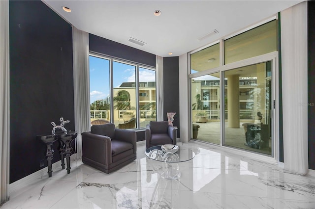 sitting room with marble finish floor, visible vents, and baseboards