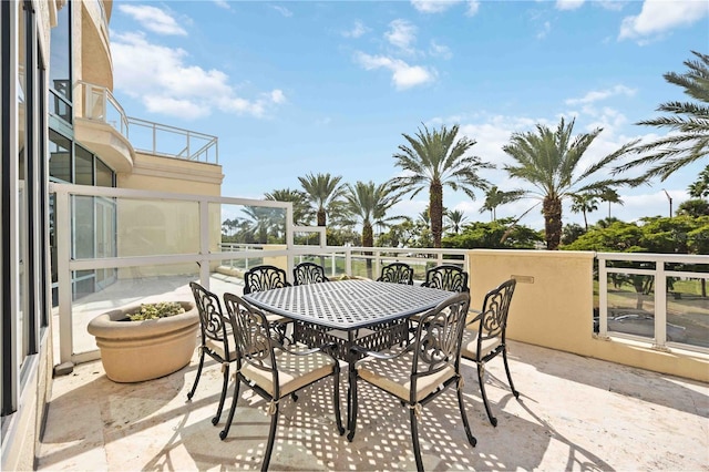 view of patio featuring outdoor dining area and a balcony