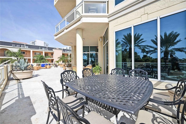 view of patio / terrace with a balcony and outdoor dining area