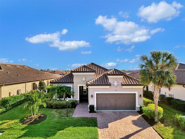 mediterranean / spanish house featuring a front lawn and a garage