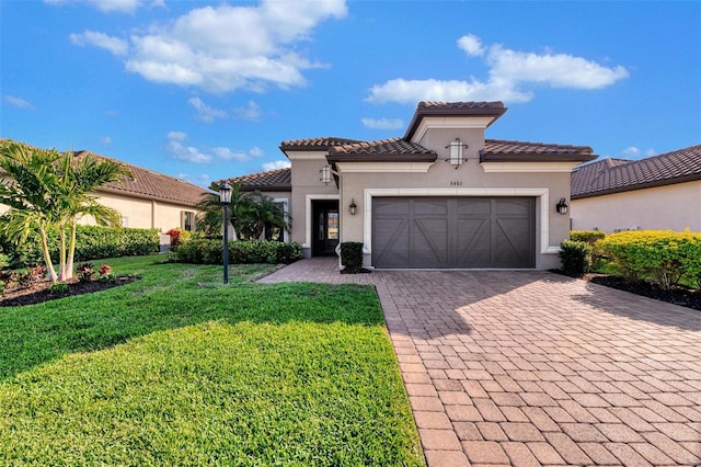 mediterranean / spanish home with a garage and a front lawn