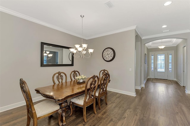 dining area featuring dark hardwood / wood-style floors, crown molding, and a chandelier