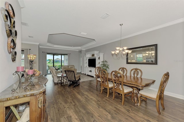 dining room featuring a raised ceiling, crown molding, dark hardwood / wood-style floors, and an inviting chandelier