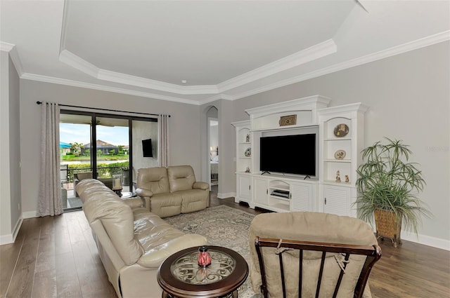 living room featuring ornamental molding, a raised ceiling, and dark wood-type flooring