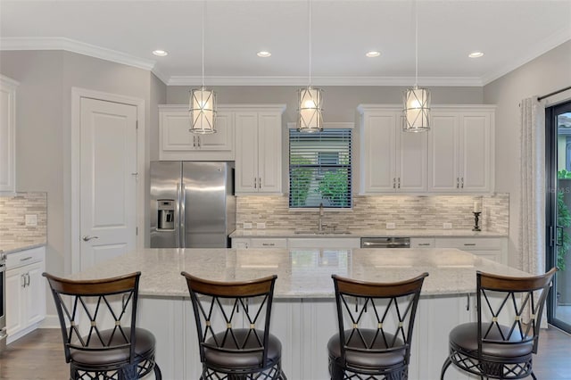 kitchen with backsplash, stainless steel appliances, a kitchen island, and hanging light fixtures