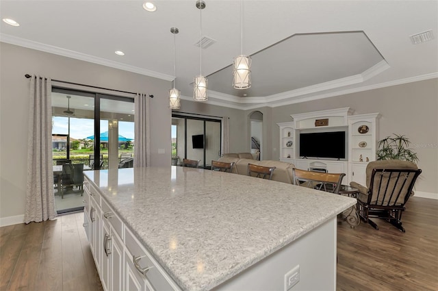 kitchen with white cabinets, a kitchen island, hanging light fixtures, and dark wood-type flooring