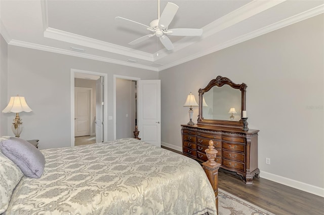 bedroom with hardwood / wood-style floors, ceiling fan, crown molding, and a tray ceiling