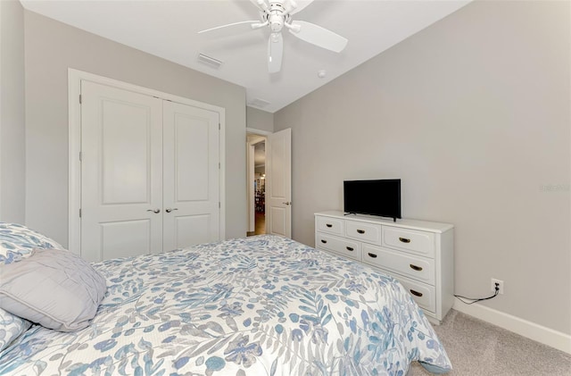 bedroom with a closet, ceiling fan, and light colored carpet