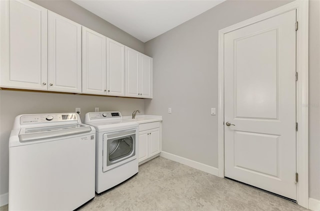 washroom with sink, cabinets, and independent washer and dryer