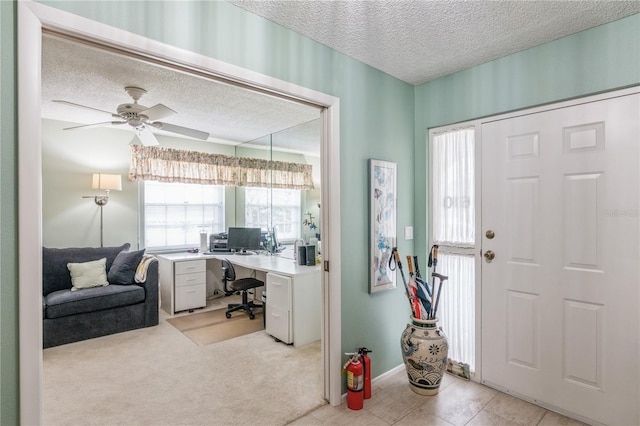 carpeted foyer with ceiling fan and a textured ceiling