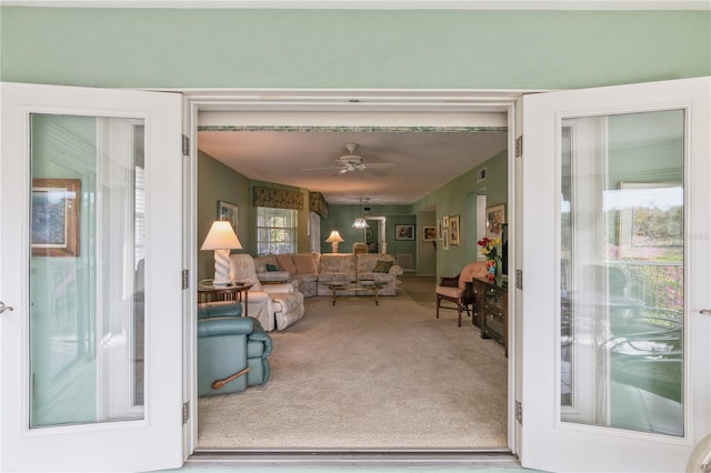 interior space featuring carpet flooring, ceiling fan, and a healthy amount of sunlight