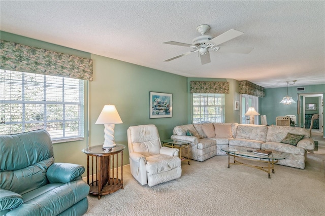 carpeted living room featuring ceiling fan and a textured ceiling