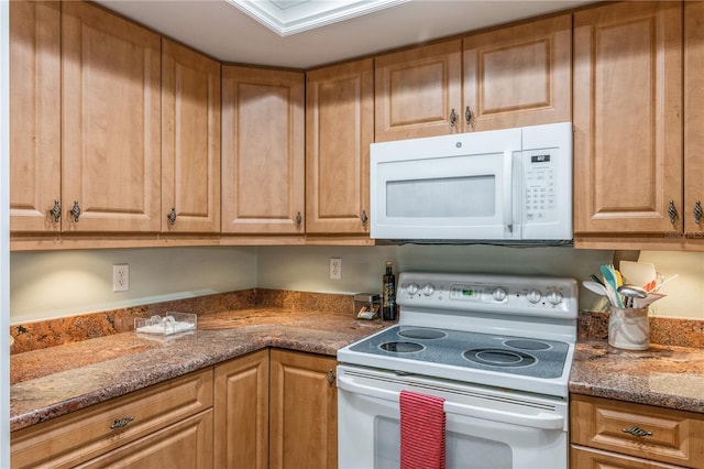 kitchen featuring stone counters and white appliances