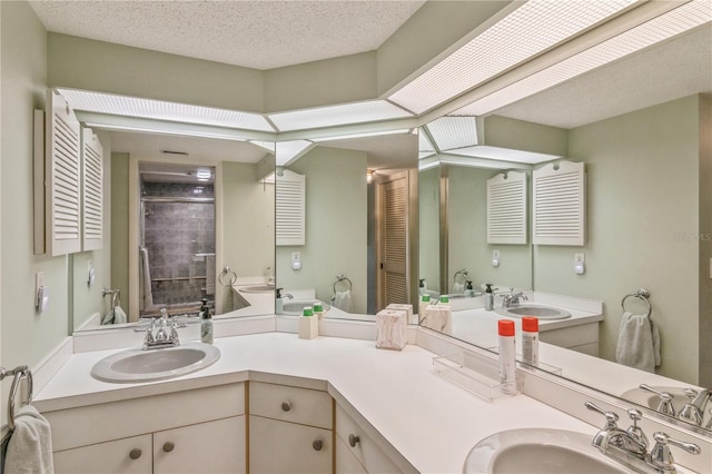 bathroom with vanity, a textured ceiling, and walk in shower