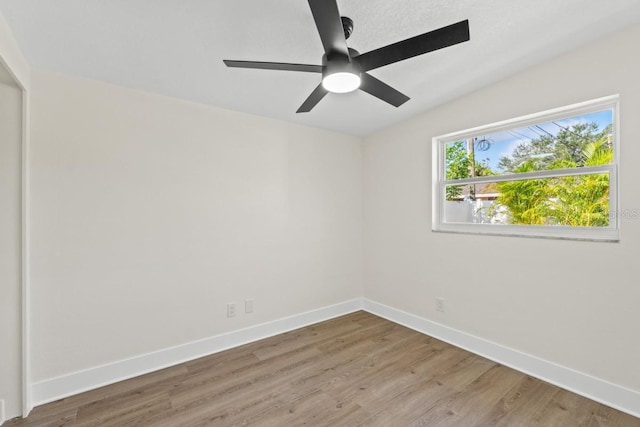 empty room with ceiling fan, vaulted ceiling, and hardwood / wood-style flooring