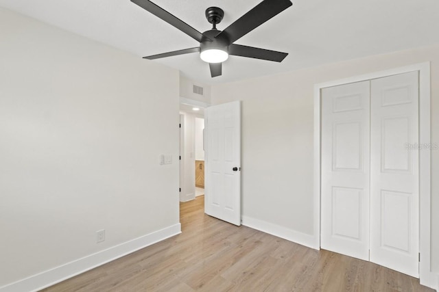 unfurnished bedroom with a closet, light hardwood / wood-style flooring, and ceiling fan