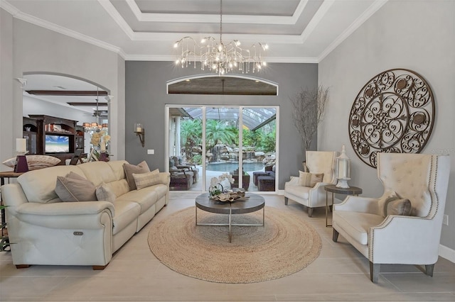 tiled living room featuring a tray ceiling, ceiling fan with notable chandelier, and ornamental molding