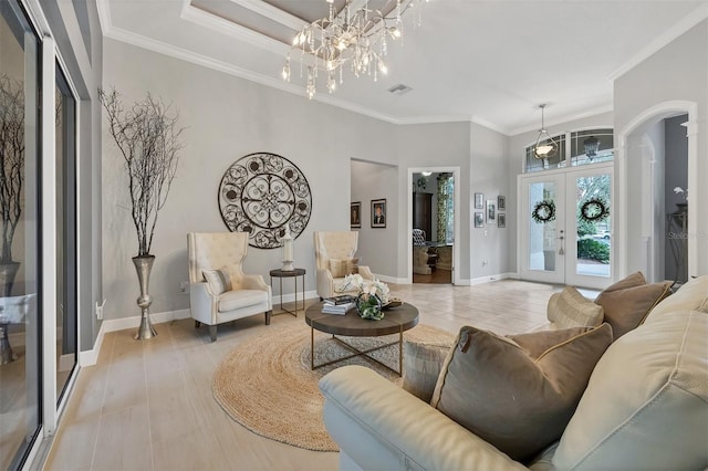 living room featuring a chandelier, french doors, and ornamental molding