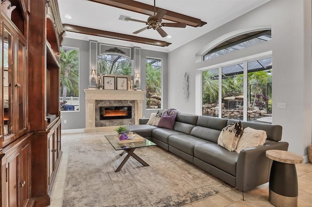 living room featuring ceiling fan, light tile patterned flooring, ornamental molding, and a high end fireplace