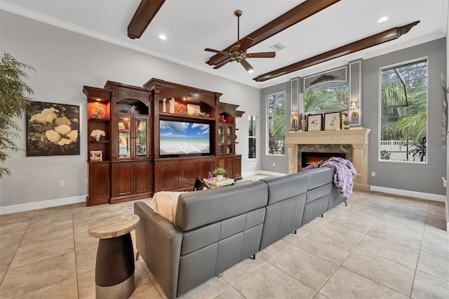 living room featuring a high end fireplace, beamed ceiling, ceiling fan, and ornamental molding