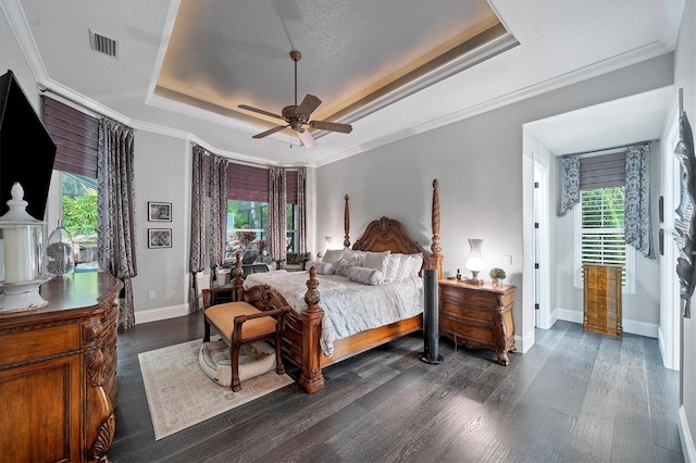 bedroom featuring a textured ceiling, a tray ceiling, ceiling fan, and crown molding