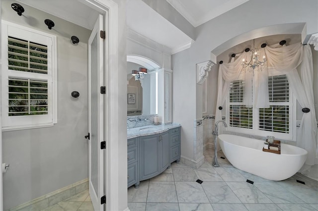 bathroom featuring a bathtub, crown molding, vanity, and a chandelier