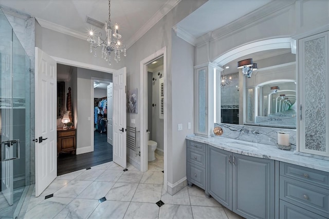 bathroom featuring an enclosed shower, ornamental molding, vanity, an inviting chandelier, and toilet