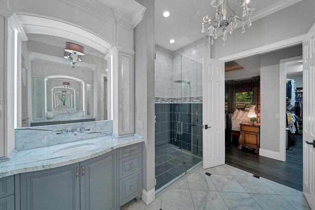 bathroom with a tile shower, vanity, and ornamental molding