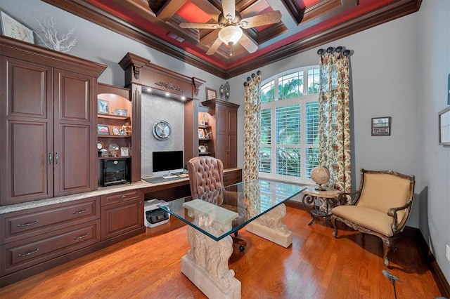 home office with coffered ceiling, beamed ceiling, crown molding, built in desk, and light wood-type flooring