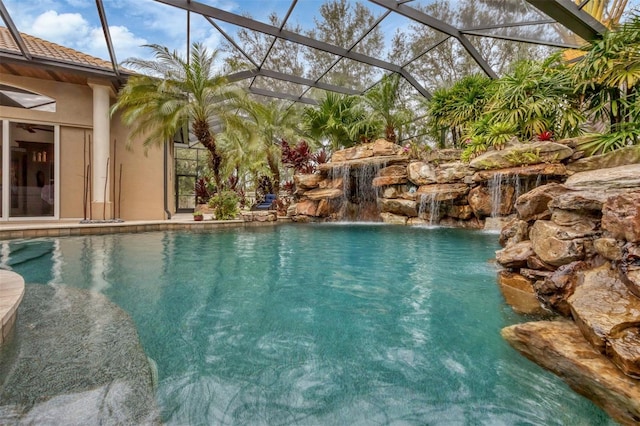 view of swimming pool featuring pool water feature and glass enclosure