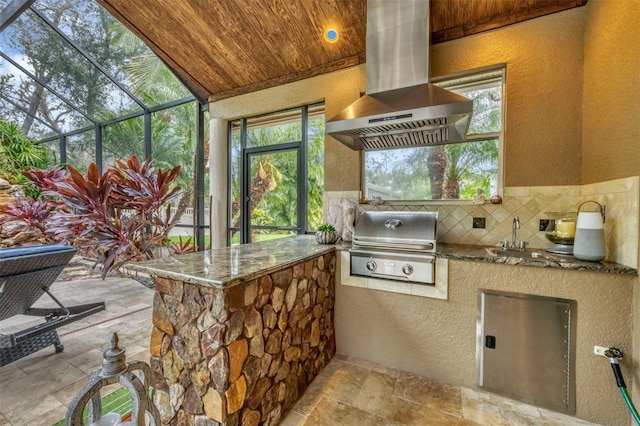 view of patio featuring a lanai, sink, and grilling area