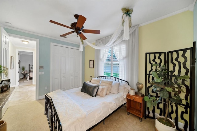 bedroom featuring a ceiling fan, a closet, light colored carpet, and crown molding