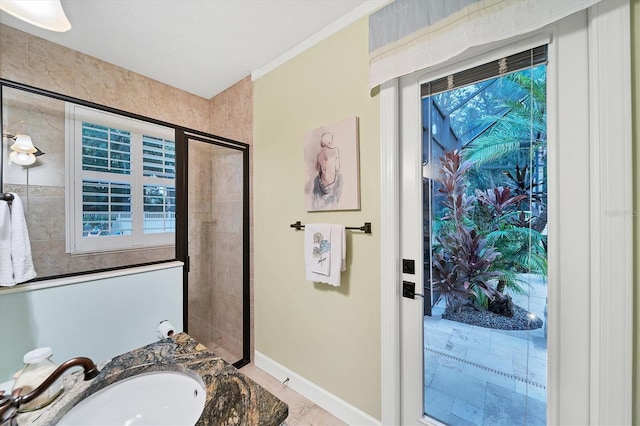 bathroom featuring a wealth of natural light, a stall shower, vanity, and baseboards