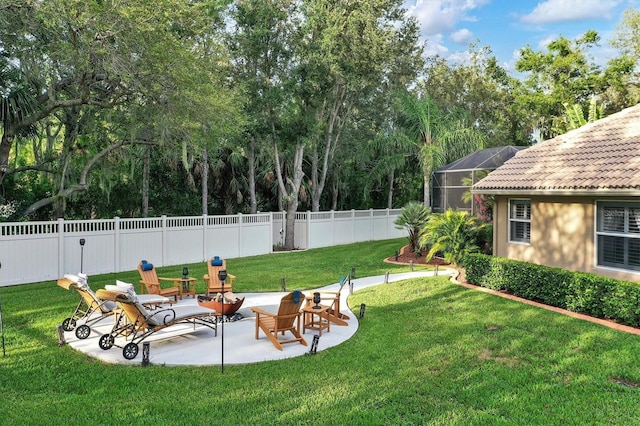 view of yard featuring a lanai, a fenced backyard, and a patio