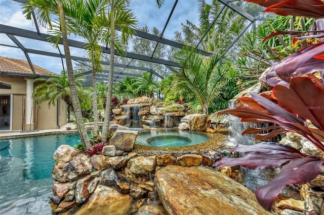 outdoor pool featuring glass enclosure and an in ground hot tub