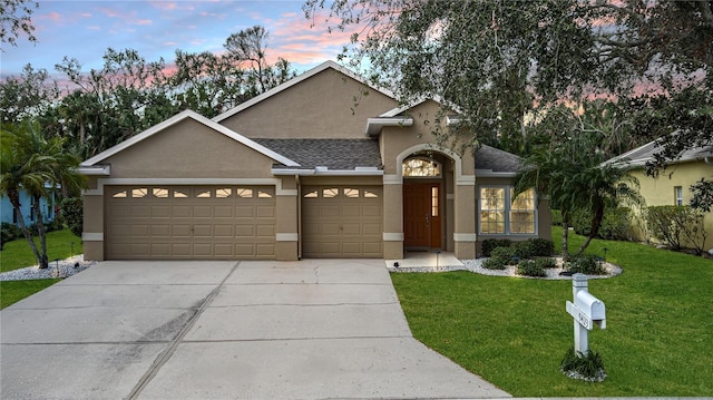 view of front of home featuring a garage and a yard