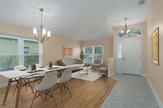 tiled dining room with a chandelier