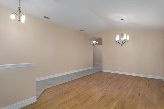 empty room featuring light hardwood / wood-style flooring and vaulted ceiling