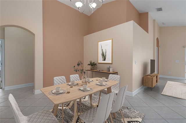 tiled dining space featuring a high ceiling and a notable chandelier