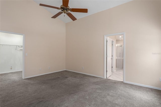 carpeted empty room with ceiling fan and high vaulted ceiling