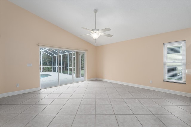 empty room with ceiling fan, light tile patterned floors, and vaulted ceiling