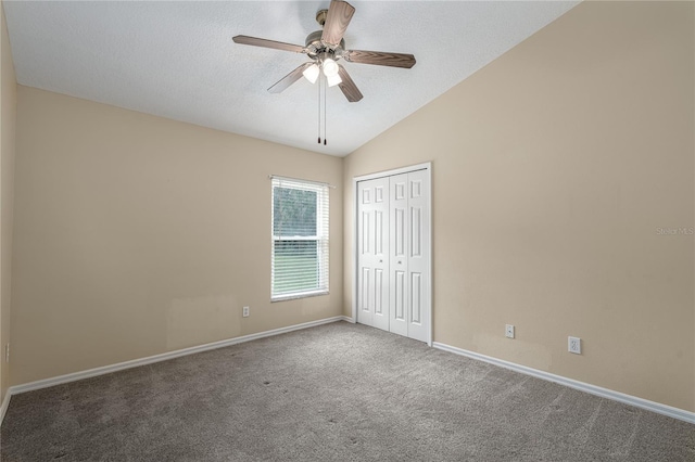 carpeted empty room with ceiling fan and lofted ceiling