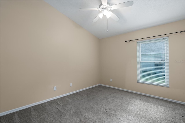 carpeted spare room with ceiling fan and vaulted ceiling