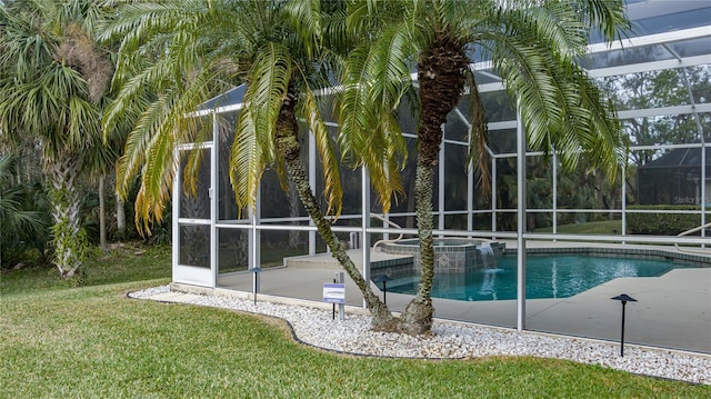 view of pool with a lawn, glass enclosure, an in ground hot tub, and a patio